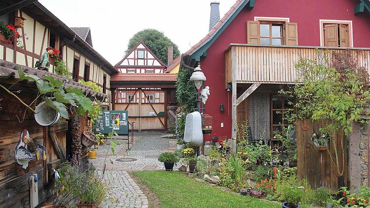 Beate Weimar-Stockmann und ihr Mann Ulrich haben den Sanierungsumbau ihres Hofes in Fuchsstadt nicht bereut. Erhaltenswertes wurde gerettet. Allerdings musste das Wohnhaus (rot) an der Ecke erst abgerissen und dann neu gebaut werden. Fotos: Gerd Schaar