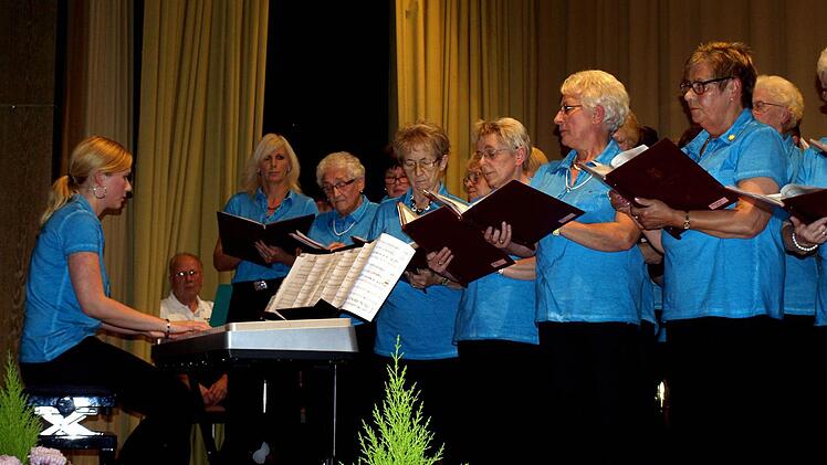 Dirigentin Yvonne Schütz am Klavier zusammen mit einem Teil der Sänger und Sängerinnen des Gesangvereins Cäcilia Wallenfels. Foto: Susanne Deuerling