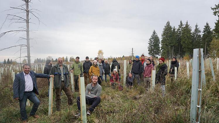 Auf der Hochfläche über dem Bauersberg haben die Schüler der Holzbildhauerschule Bischofsheim 700 junge Linden gepflanzt. Mit im Bild (links vorne) ist der Vertreter der Marktgemeinde Oberelsbach, Harald Omert, und (zweiter von links) Förster Matthais Schlund. Foto: Marion Eckert