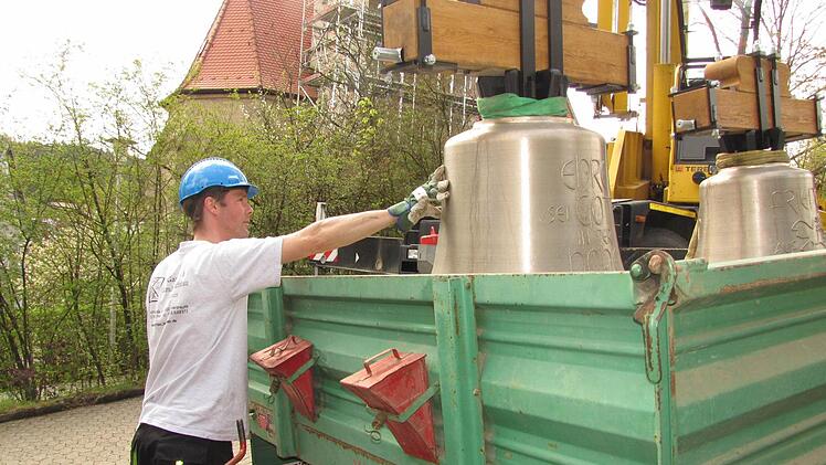 Thorsten Riedel von der Fa. Bayreuther Turmuhren vertäut die neuen Glocken, bevor sie von einem Kran auf den Seidmannsdorfer Kirchturm gehievt werden. Foto: Martin Koch