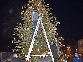Die Mitglieder des Bürgervereins "Lebendiges Redwitz" mit Vorsitzendem Stephan Arndt (rechts) beim Aufhängen der Christbaumkugeln an den großen Christbaum vor dem Bürgerhaus  Foto: Thomas Micheel