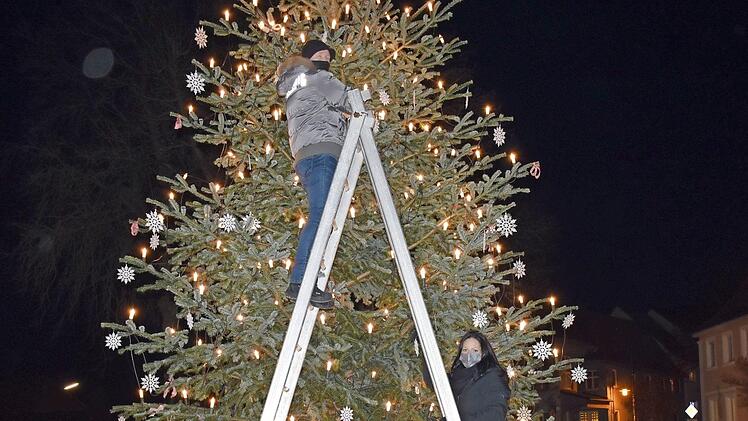 Die Mitglieder des Bürgervereins "Lebendiges Redwitz" mit Vorsitzendem Stephan Arndt (rechts) beim Aufhängen der Christbaumkugeln an den großen Christbaum vor dem Bürgerhaus  Foto: Thomas Micheel