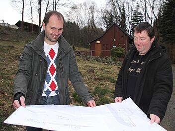 Der Vorsitzende des Frankenwaldvereins Wartenfels, André Hümmer, und sein Stellvertreter Klaus Gareis mit den ersten Planungen für den Neubau. Dort, wo einst der Gemeindewald war, soll eine Lagerstätte aus Holz errichtet werden. Foto: Sonja Adam