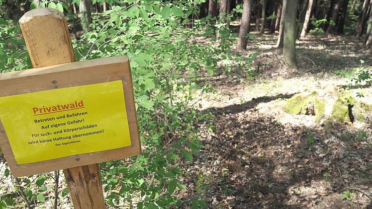Ein Grundst&uuml;ckseigent&uuml;mer am Buchberg weist mit einem Schild darauf hin, keine Haftung zu &uuml;bernehmen. Daneben f&uuml;hrt eine Downhillstrecke zu einer Schanze aus Getr&auml;nkekisten. Foto: Christoph Winter