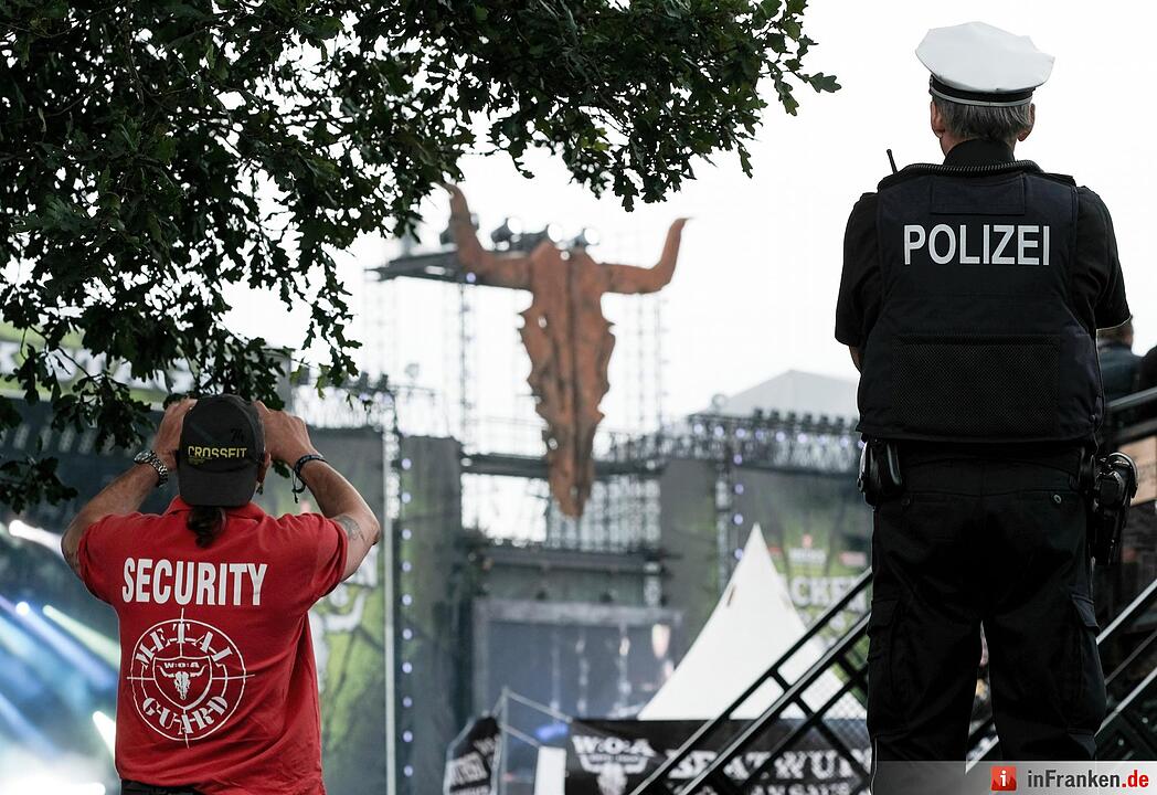 Ein Polizist und ein Security-Mitarbeiter schauen am 04.08.2016 in Wacken (Schleswig-Holstein) auf das Gelände des Wacken Open Air. 75.000 Fans feiern das nach Veranstalterangaben größte Heavy-Metal- Festival der Welt.
