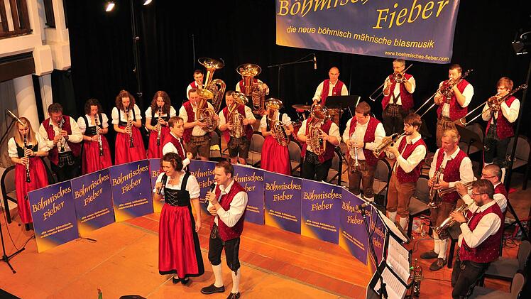 Ein abwechslungsreiches Programm an schönen böhmischen Polkas, Märschen und Walzern präsentierte das "Böhmische Fieber" bei seinem Konzert in der ausverkauften Stadthalle in Haßfurt unter der Leitung von Florian Unkauf. Im Vordergrund die Sänger Sonja Vollmuth und Michael Selig.