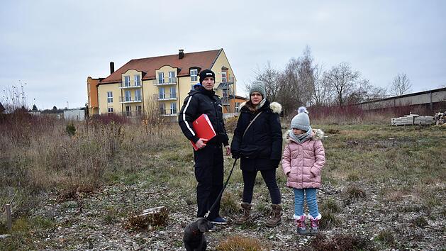 Oliver Katzenberger und Verena Huber mit Tochter Amelia auf dem Baugebiet.  Ihr Grundst&uuml;ck liegt im Hintergrund beim Altenheim. Foto: Petra Malbrich