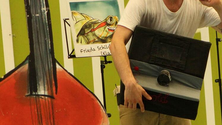 Dirigent Herbert Karavan bei Fotoaufnahmen der verschiedenen Tiere und ihrer Instrumente. Foto: Günther Geiling