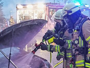 Die Feuerwehrleute löschten den Autobrand ab.