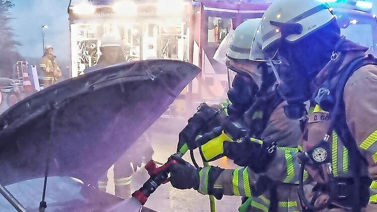 Die Feuerwehrleute löschten den Autobrand ab.