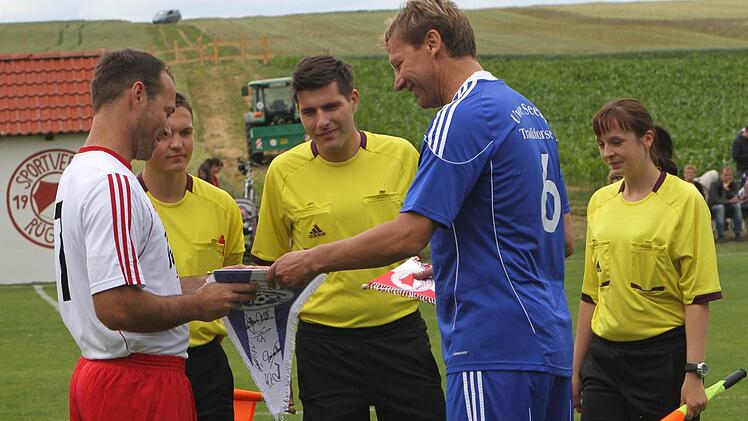 Die beiden Kapitäne Steffen Lutz (links) und Guido Buchwald beim Austausch der Wimpel. Im Hintergrund die Schiedsrichter.