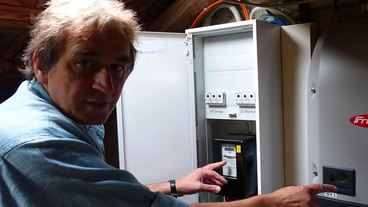 In seinem Dachboden zeigt der Energieberater Günter Lieberth seinen Stromzähler sowie den für die Solaranlage installierten Wechselrichter. Der Experte möchte möglichst viele Hausbesitzer ermutigen, seinem Beispiel zu folgen. Foto: Manfred Wagner