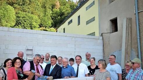 Zweiter Bürgermeister Karl Opel und Landrat Klaus Peter Söllner vollzogen die Grundsteinlegung fürs Bürgerzentrum. An der Mauer (von links) Regierungsdirektorin Marion Resch-Heckel, Opel und Söllner, Architekt Hans-Hermann Drenske und Pfarrer Peter Brünnhäußer. Foto: W. Reißaus
