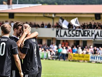 Klassenerhalt! Sebastian Wagner, Chris Gonnert und Flo Gundelsheimer umarmen sich nach dem Sieg, im Hintergrund feiern die Fans. Ryan Evans