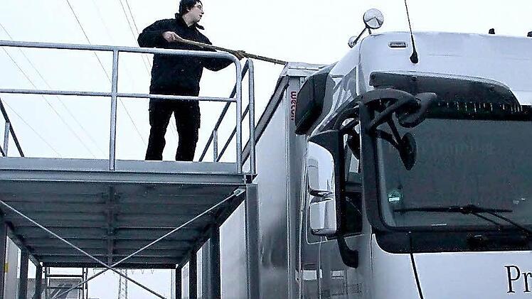 Alexander Laskan ist dabei, einen Lastwagen von Eis zu befreien. Der 22-Jährige aus Kulmbach absolviert derzeit eine Ausbildung zum Berufskraftfahrer und ist im zweiten Lehrjahr. Foto: Jürgen Gärtner