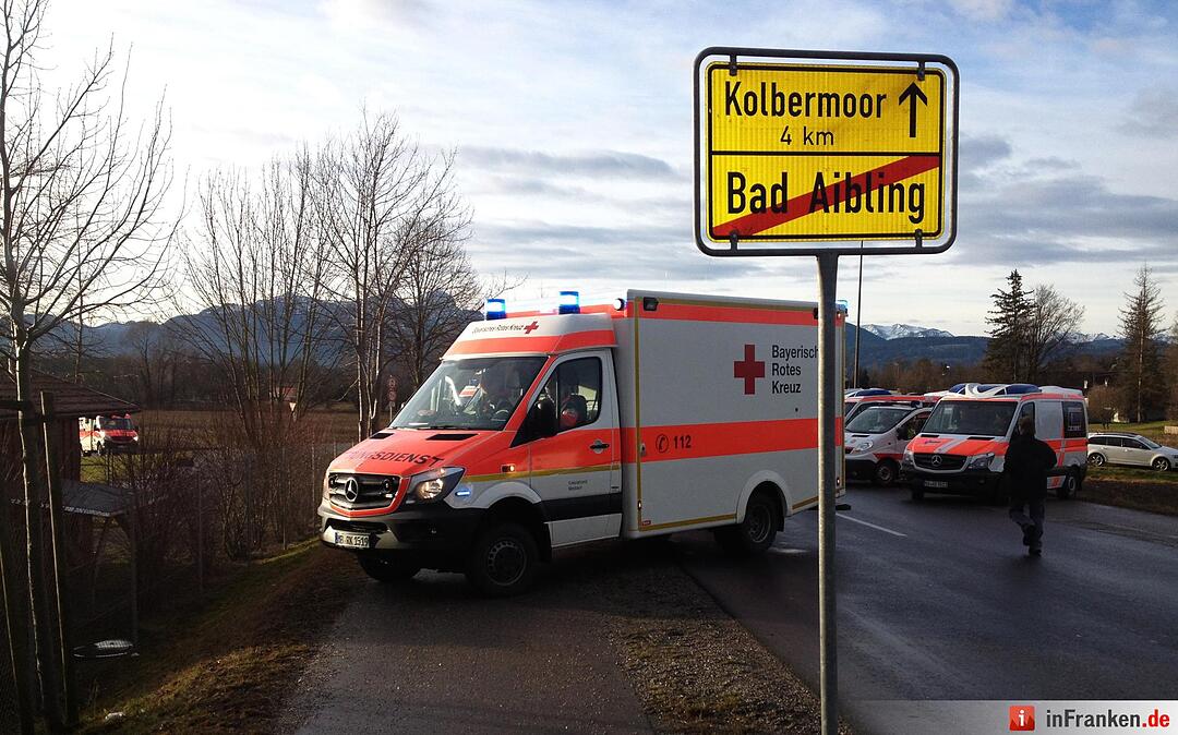 Rettungswagen stehen am 09.02.2016 an dem Ortsausgangsschild von Bad Aibling. Bei einem Zugunglück in der Nähe von Bad Aibling (Landkreis Rosenheim) sind am Dienstagmorgen mehrere Menschen ums Leben gekommen.