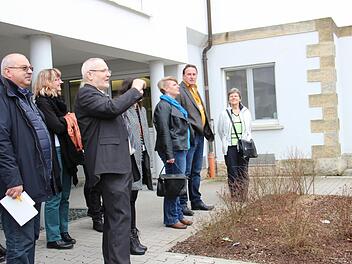 Gotthard Lehner führt Dutzende Gäste durch die Klinik und über das Gelände. Hier steht die Gruppe vor dem ersten Gebäude des Klinikkomplexes, das lange das "Männerhaus" war.  Foto: Katharina Müller-Sanke