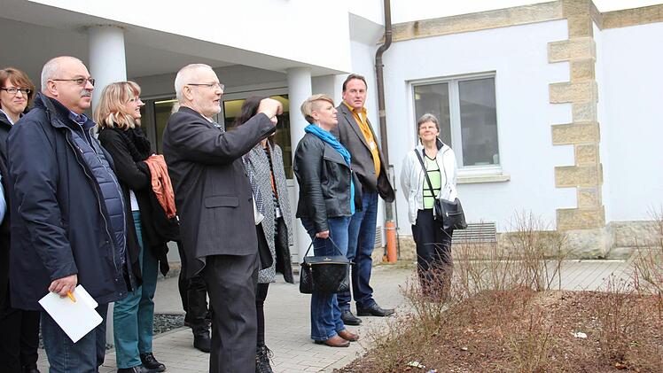 Gotthard Lehner führt Dutzende Gäste durch die Klinik und über das Gelände. Hier steht die Gruppe vor dem ersten Gebäude des Klinikkomplexes, das lange das "Männerhaus" war.  Foto: Katharina Müller-Sanke