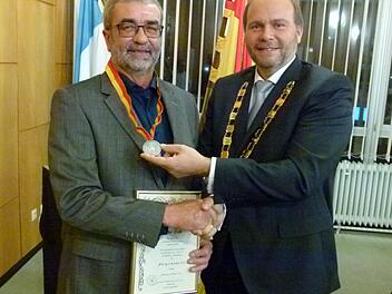 Gemeinderat Volker Derks (links) erhält von Bürgermeister Bernd Reisenweber die Bürgermedaille. Foto: Lothar Weidner