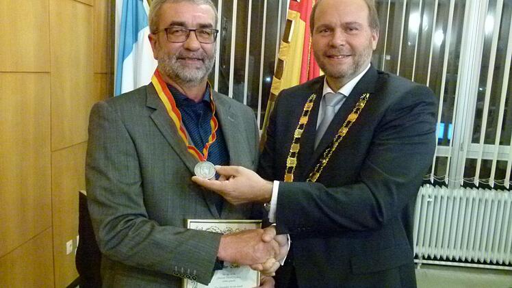 Gemeinderat Volker Derks (links) erhält von Bürgermeister Bernd Reisenweber die Bürgermedaille. Foto: Lothar Weidner