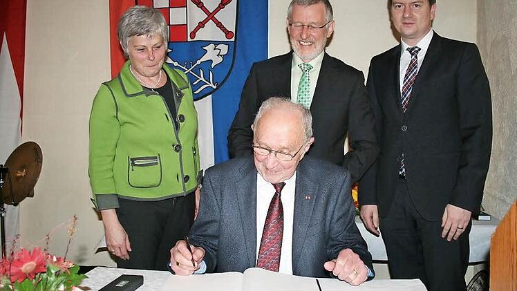 Eintrag ins Goldene Buch: Alfred Saam (vorne) erhielt die Bürgermedaille des Marktes Burkardroth. Hinten (von links) Elisabeth Kuhen, Bürgermeister Waldemar Burg und Sandro Kichner.