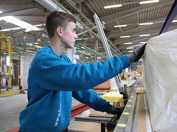 Arbeit für ein Dachelement: Nach dem Ausmessen sägt Zimmerer-Azubi Tobias Frischat die Dämmwolle zurecht... Foto: Benedikt Borst