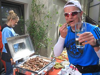 Diplom-Braumeister Stefan Gottschall nach gut 20 Kilometern mit Bratwurst und einem (Schluck) Bier. Er erreichte sein persönliches Laufziel mit einer Zeit von unter vier Stunden. Foto: Bertram Wagner