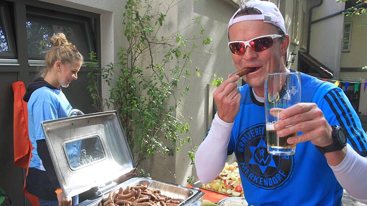 Diplom-Braumeister Stefan Gottschall nach gut 20 Kilometern mit Bratwurst und einem (Schluck) Bier. Er erreichte sein persönliches Laufziel mit einer Zeit von unter vier Stunden. Foto: Bertram Wagner