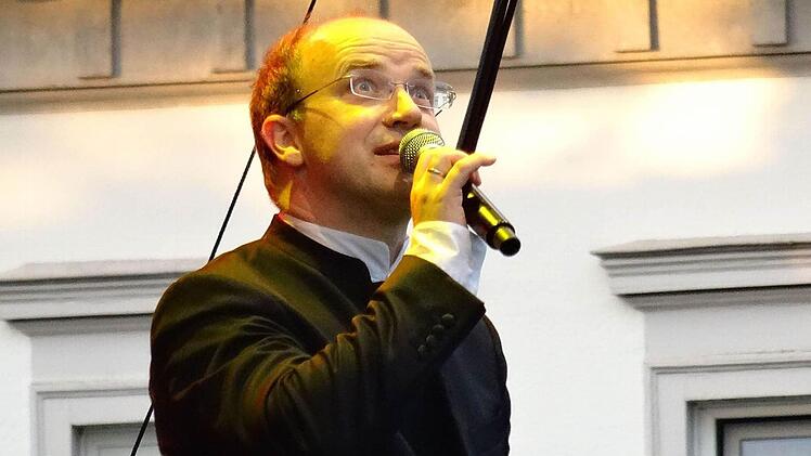 Dirigent und Moderator Roland Kluttig: Bange Blicke zum Himmel am Anfang des Konzerts.Foto: Jochen Berger