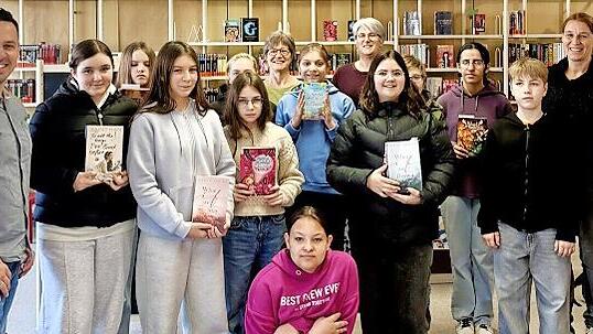 Sch&uuml;lerinnen und Sch&uuml;ler der Sinntalschule freuen sich mit dem Team der Gemeindebibliothek, Heike Kettemer und Sabine Loeber, sowie der Rektorin Christiane Helfrich und dem Gesch&auml;ftsleiter des Marktes Wildflecken, Daniel Kleinheinz, &uuml;ber den neuen...