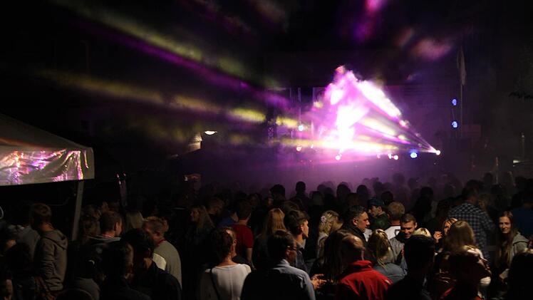 Stadtfest Bad Brückenau 2015: Vor der Jugendbühne in der Altstadt drängen sich die Leute, während eine Laser-Show den Nachthimmel mit bunten Farben beleuchtet. Foto: Friedemann Müller