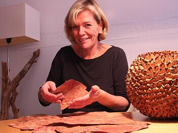 Martina Straub zeigt das Furnierholz, das den stabilen Rahmen für diese Kugel aus Bucheckern bildet. Foto: <?Fotos:?><?_Fotos:?>Heike Beudert