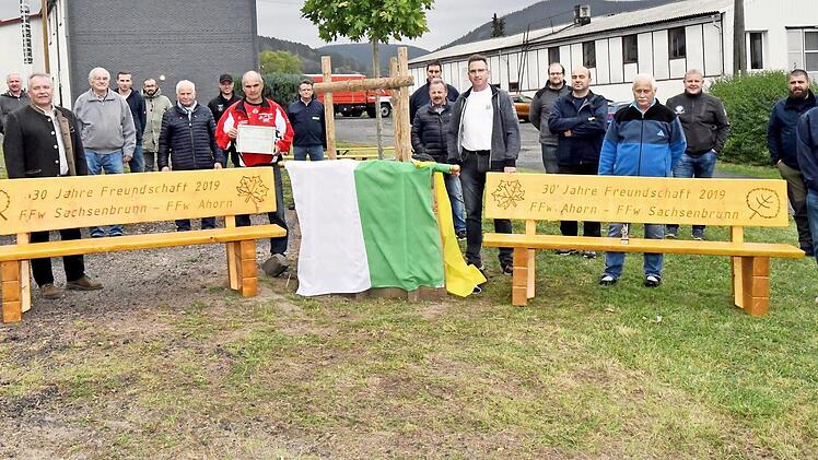 Stolze Gesichter: Mit der &Uuml;bergabe der "B&auml;nke der Freundschaft" sind die Feuerwehren aus Ahorn und Sachsenbrunn &uuml;berrascht worden. Foto: Karl-Wolfgang Flei&szlig;ig