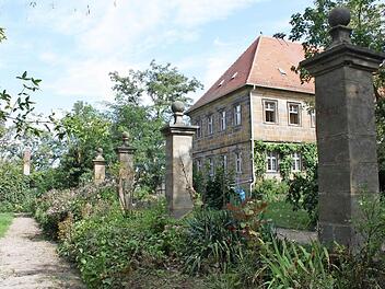 Die Sandsteinsäulen des ehemaligen Gartenzaunes mit einem der altenKlostergebäude. Links der Klostergarten. Fotos: LAG