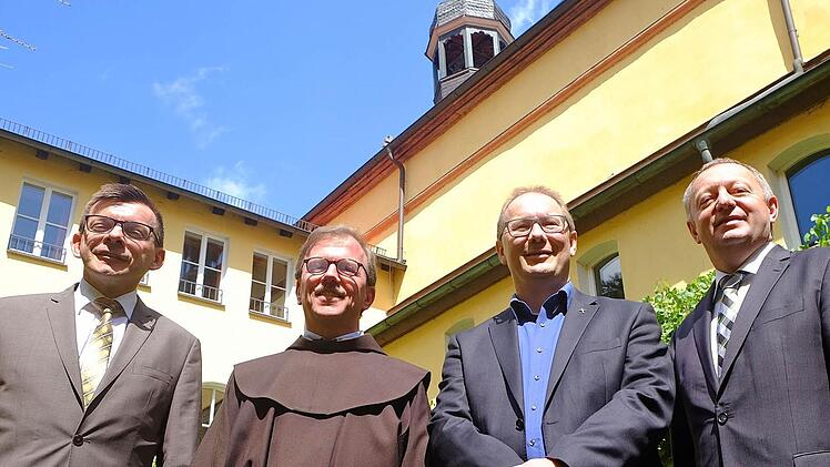 Besiegelten den Besitzerwechsel: Bürgermeister Armin Warmuth (von links), Franziskaner- Provinzialminister Pater Cornelius Bohl, Stadtpfarrer Thomas Eschenbacher und Landrat Thomas Bold im Innenhof des Klosterkreuzgangs. Foto: Gerd Schaar