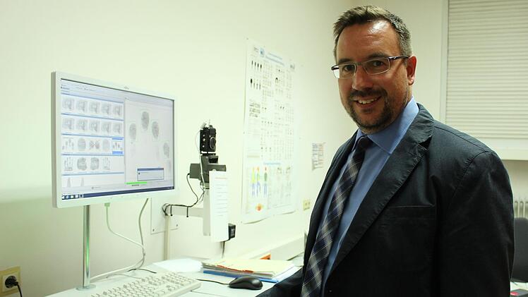 Fürs Foto demonstriert der neue Kripo-Chef Rainer Schmeußer, wie der moderne Fingerabdruck-Scanner in der Coburger Dienststelle arbeitet. Foto: Ulrike Nauer