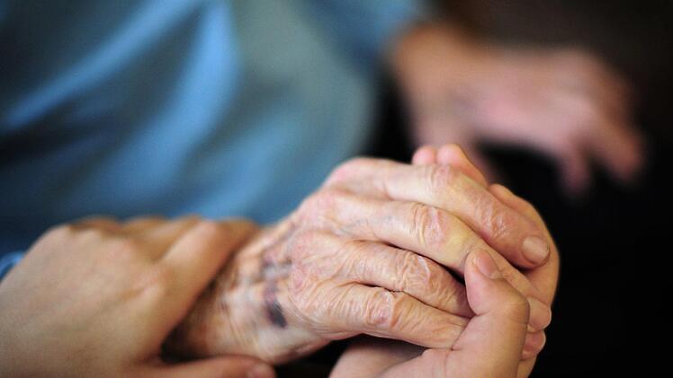 Die Hand halten und so N&auml;he vermitteln: Die M&ouml;glichkeiten, Sterbenden zu helfen, sind vielf&auml;ltig.Daniel Reinhardt, dpa