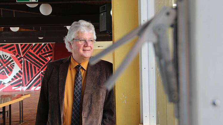 Schulleiter Helmut Schreiner in der Aula des Frobenius-Gymnasiums. Fenster und Fassade sind noch aus den 1960er Jahren.  Foto: Benedikt Borst