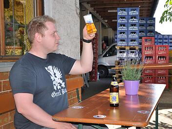 Mit dem Blick des Fachmanns prüft Christian Schuster das von ihm gebraute Bier vor der heimischen Gaststätte. Foto: Leo Hühnlein