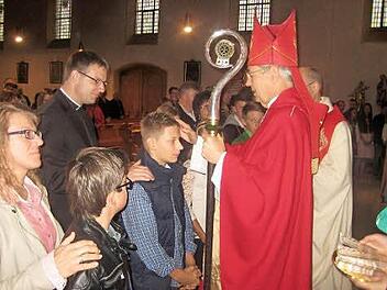 Maximilian Greser wird von Erzbischof Ludwig Schick gefirmt. Firmpate des Firmlings ist Holger Fiedler, Priester in Hof. Foto: Paul Hader