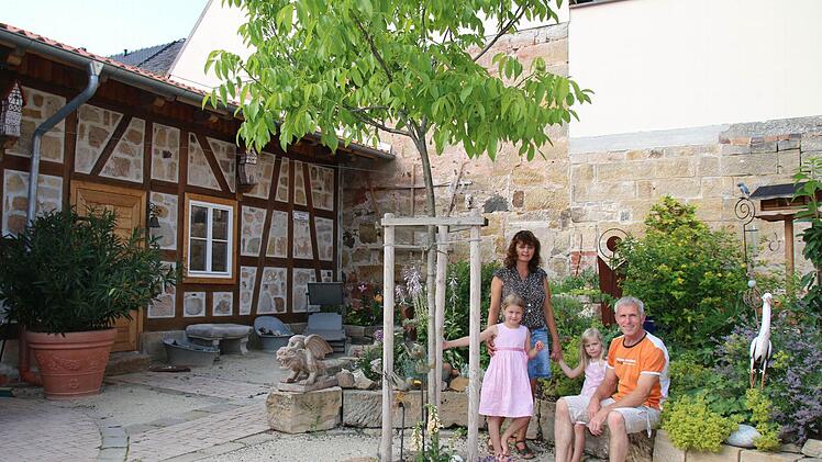 Nur selten finden Manuela und Peter Hofmann bisher Zeit und Muße, ihre selbstgeschaffene Idylle auf ihrem Anwesen in der Seßlacher Pfarrgasse zu genießen. Für die vorbildliche Sanierung des stattliches Wohnhaus und des Innenhofs samt Scheune im Schatten der Stadtmauer wurde das Ehepaar vom bayerischen Kultusminister Dr. Ludwig Spaenle in München gerade mit der "Denkmalschutzmedaille 2015" ausgezeichnet. Auch die Töchter Leni (7, links) Lilly (5) und fühlen sich in dem neuen alten Anwesen sehr...