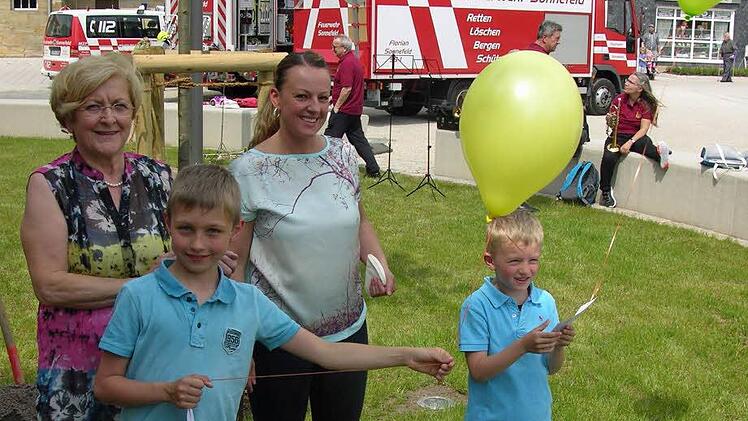 Leon und Robbin lassen ihre Luftballons zum Wettfliegen steigen. Die Seniorenbeauftragte Christa Röder und Kristina Koch stehen hilfreich zur Seite. Foto: Klaus Oelzner