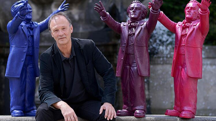 Der Künstler inmitten seiner Werke: Ottmar Hörl installierte 2013 etwa 500 der bonbonbunten Mini-Wagner am Bayreuther Festspielhügel. Zehn Exemplare seiner Plastik-Komponisten, aus Aluminium gegossen, wollte er der Stadt schenken - doch die Verwaltung lehnte ab.  Foto: David Ebener/dpa
