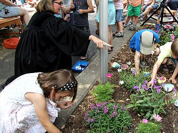 Als symbolischen Akt säten die Kinder mithilfe von Pfarrerin Mützlitz Blumen in einem Beet vor dem Familienzentrum. Foto: Richard Sänger