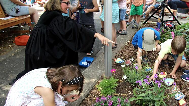 Als symbolischen Akt säten die Kinder mithilfe von Pfarrerin Mützlitz Blumen in einem Beet vor dem Familienzentrum. Foto: Richard Sänger