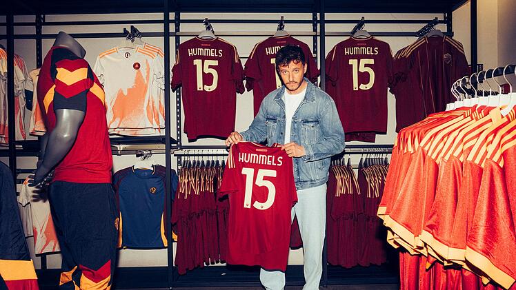 Trikots mit der Aufschrift Hummels dürften im Laufe einer langen Karriere einige über den Ladentisch gegangen sein. Tommi Schmitt hält ehrfürchtig ein Mats Hummels-Trikot in die Kamera.