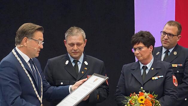 Karsten Fischkal übergibt Jürgen Hörrlein (2. v. l.) die Ehrenurkunde und Bürgermedaille seiner Gemeinde.    Foto: Tina Meier