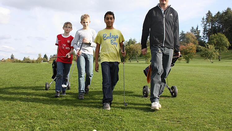 Peter Baum (rechts) mit den Schülern Pujan, Olver und Christian (von rechts) auf dem Golfplatz