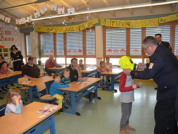 Feuerwehrleute und Schulkinder saßen gemeinsam auf der Schulbank. Die Schüler lernten das richtige Verhalten bei Feuer und Rauch, die Feuerwehrleute schulten sich im fachgerechten und kindgerechten Ausbilden von Schülern. Fotos: Karl-Heinz Hofmann