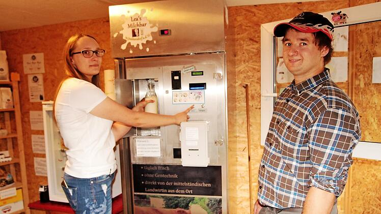 Lea Schleicher und Friedrich Grimmer am Automaten für Frischmilch im Hofladen und der Milchtankstelle